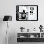 Framed artwork on a wall above a shelf with decorative items