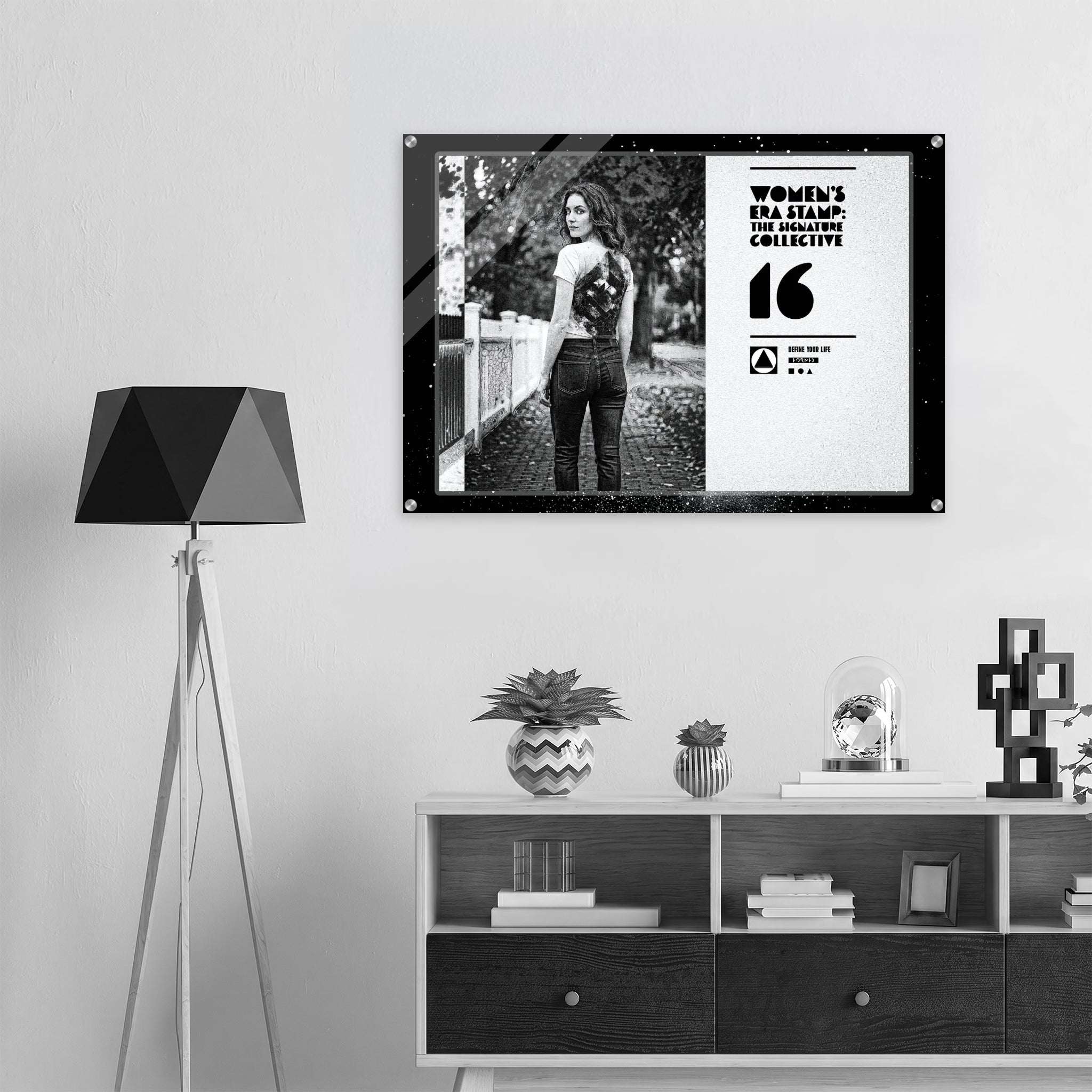 Framed photo of a woman standing outdoors on a wall above a shelf with decorative items.