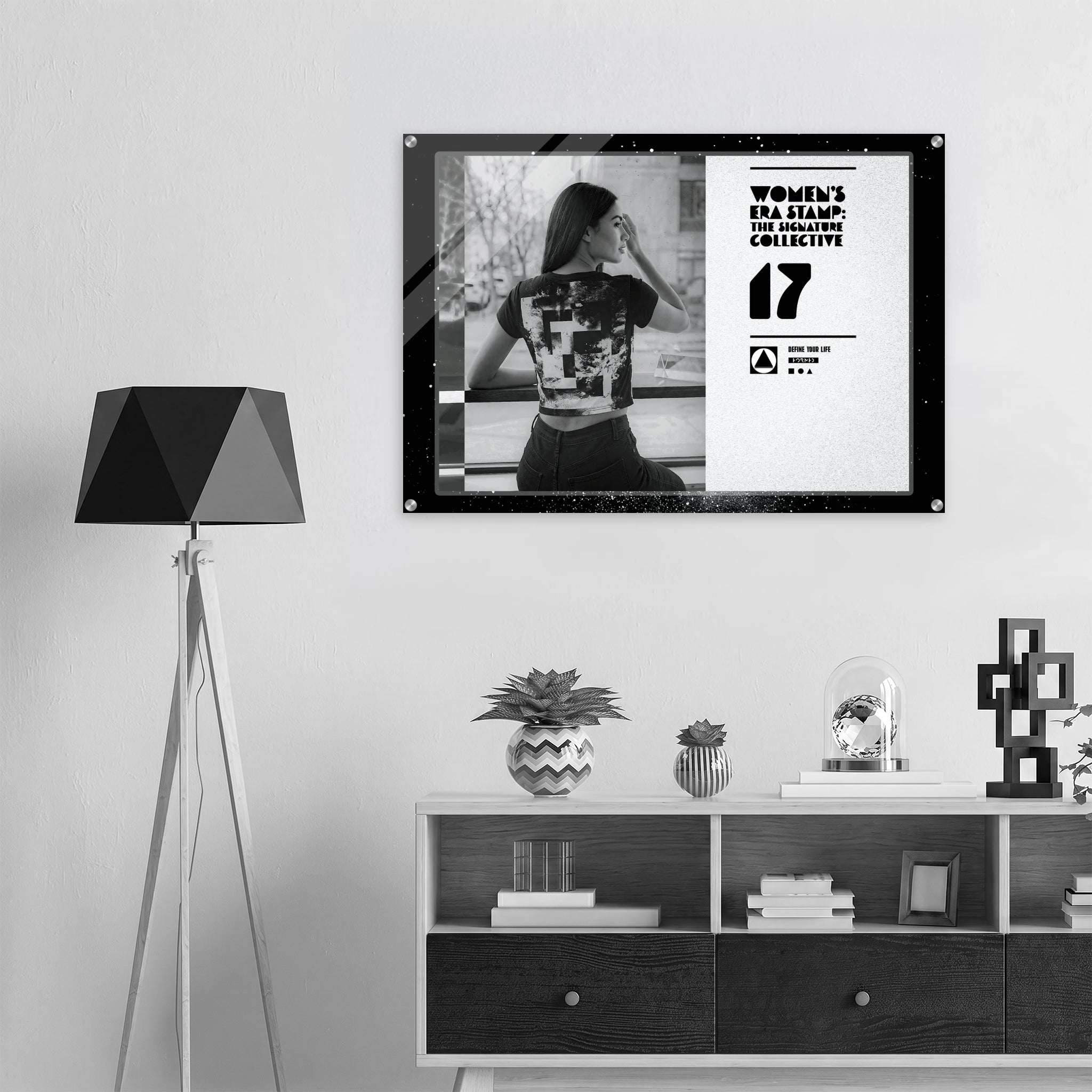 Framed artwork on a wall above a shelf with decorative items