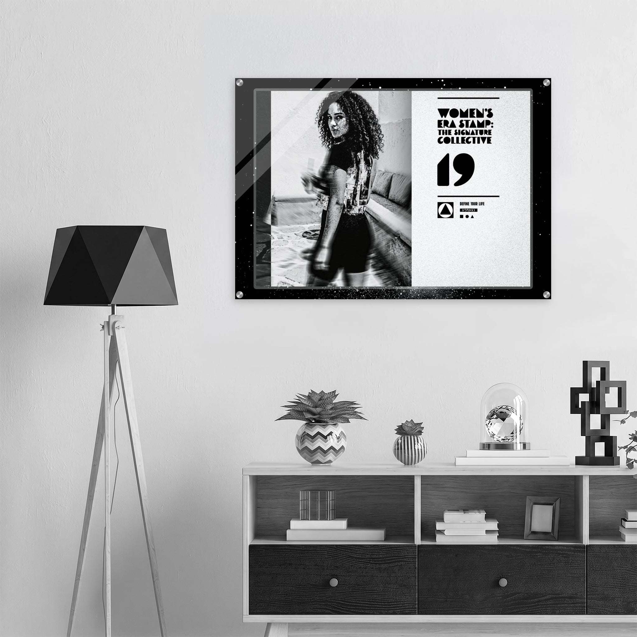 Framed poster of a woman with text on a wall above a shelf with decorative items.