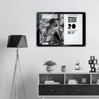 Framed poster on a wall above a shelf with decorative items