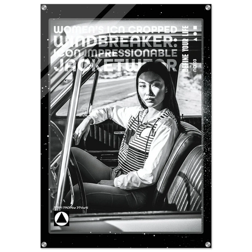 A black and white fashion poster or print featuring a seated woman in a car interior, with large overlaid text reading 'WOMEN'S ICON CROPPED WINDBREAKER: IMPRESSIONABLE JACKETWEAR'. The poster has a dark border and is shown against a light neutral background.
