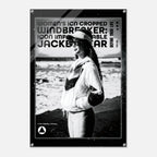A black and white poster print featuring a woman in a windbreaker jacket on a beach, with bold text reading 'WOMEN'S ICON CROPPED WINDBREAKER: ICON IMPRESSIONABLE JACKETWEAR 'DEFINE YOUR LIFE' and a small logo at the bottom.