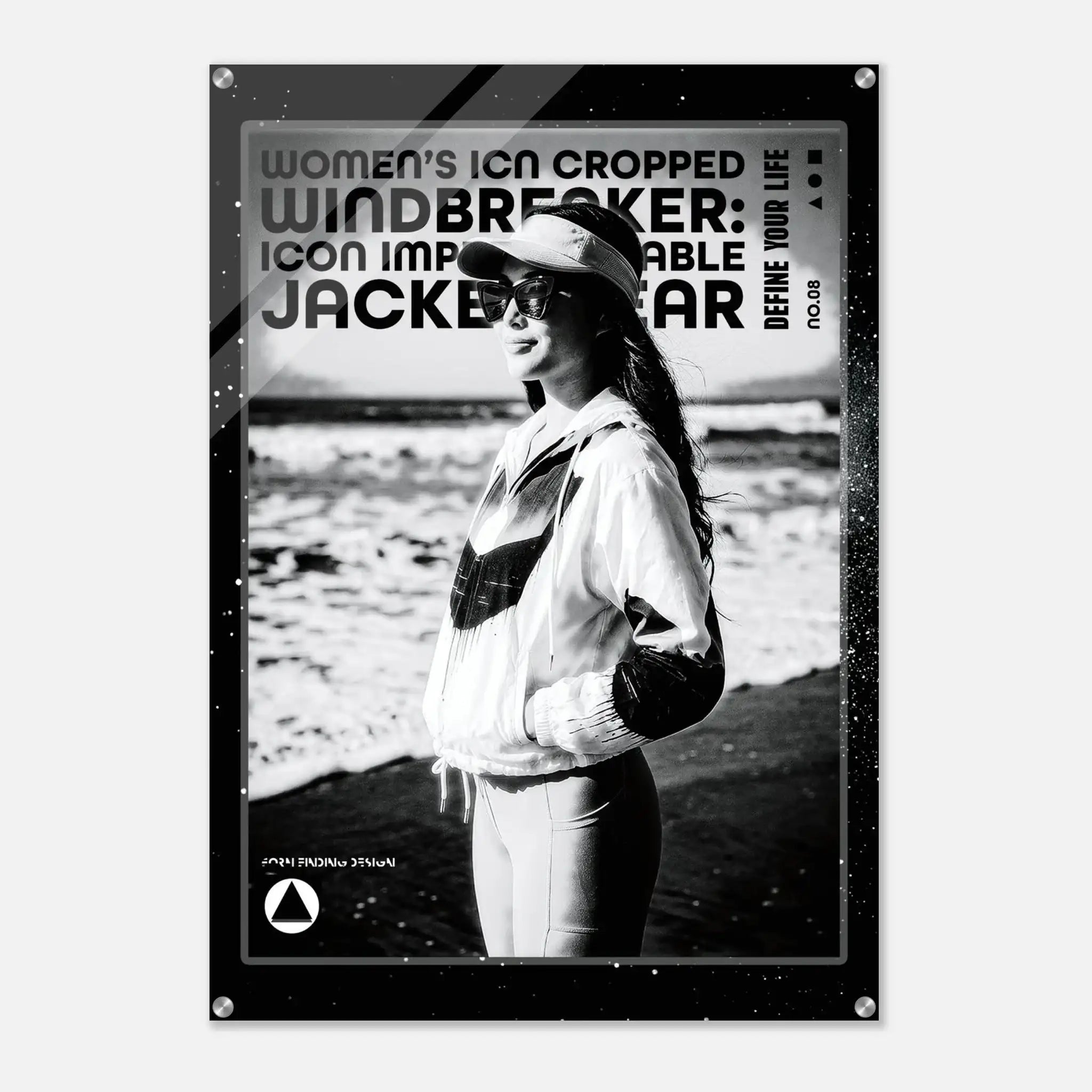 A black and white poster print featuring a woman in a windbreaker jacket on a beach, with bold text reading 'WOMEN'S ICON CROPPED WINDBREAKER: ICON IMPRESSIONABLE JACKETWEAR 'DEFINE YOUR LIFE' and a small logo at the bottom.