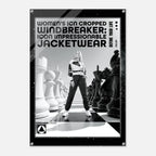 A black and white fashion poster featuring a model standing on a chessboard with oversized chess pieces, with bold text reading 'WOMEN'S ICN CROPPED WINDBREAKER: ICON IMPRESSIONABLE JACKETWEAR'.