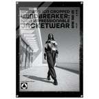 A black and white promotional poster or print featuring a woman walking outdoors in a striped jacket and pants, with large text reading 'Women's Icon Cropped Windbreaker: Icon Impressionable Jacketwear' and smaller text 'Define Your Life.' The print has a black border with small silver corner hardware and is shown against a light neutral background.