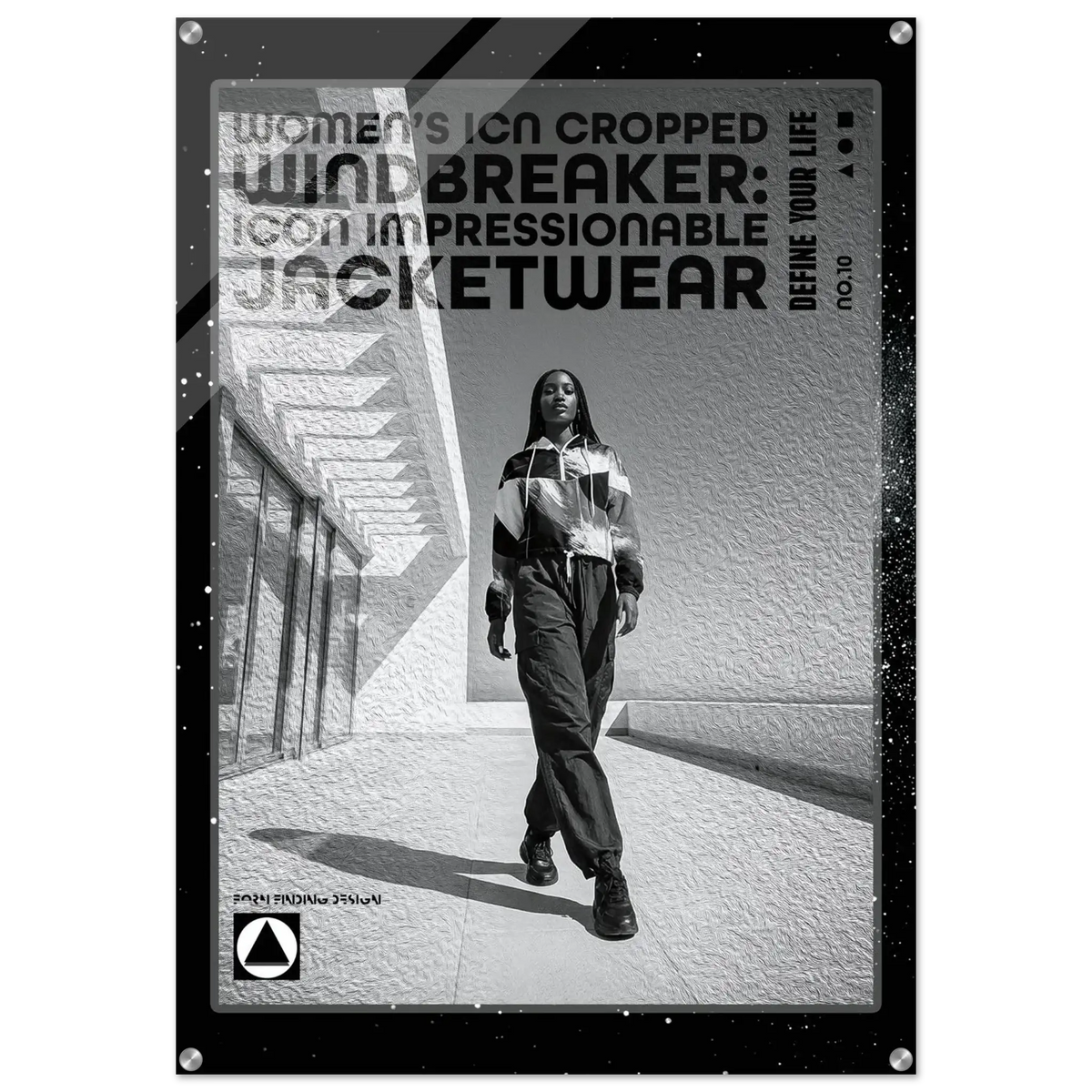 A black and white promotional poster or print featuring a woman walking outdoors in a striped jacket and pants, with large text reading 'Women's Icon Cropped Windbreaker: Icon Impressionable Jacketwear' and smaller text 'Define Your Life.' The print has a black border with small silver corner hardware and is shown against a light neutral background.