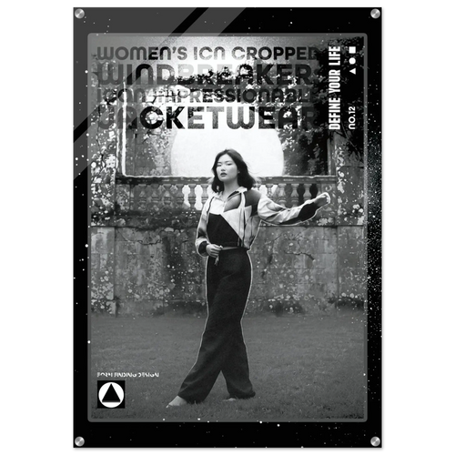 A black and white fashion poster or print featuring a woman standing outdoors in front of a stone wall, wearing a cropped jacket and wide-leg pants. Large distressed text across the top reads 'WOMEN'S CROPPED WINDbreaker JACKETWEAR' with smaller text including 'DEFINE YOUR LIFE'.