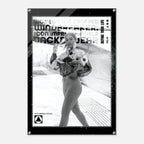 A black-framed poster or art print featuring a black-and-white fashion photograph of a woman on a train platform, with bold text overlays including 'WINDBREAKER', 'DEFINE YOUR LIFE', and 'NO.19'.