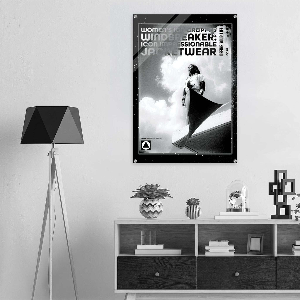 A black and white poster for formfd, hangs on a light gray wall in a modern, minimalist room setting with a tripod floor lamp and a low wooden shelf.