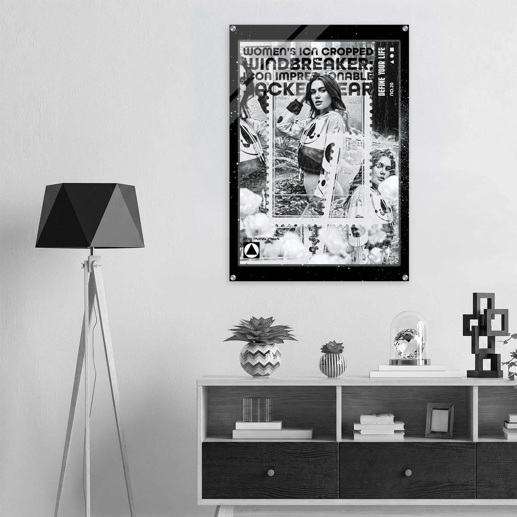 A black and white retro-style poster featuring a collage of women's ice hockey players and bold text reading 'women's icon CROPPED WINDBREAKER IMPRESSIONABLE JACKETWEAR', displayed on a light gray wall above a modern shelf in a styled interior setting.