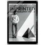 A black and white fashion poster-style product image for a women's signature hoodie. A person stands wearing a light hoodie with a graphic print and jeans, beside a large geometric pyramid shape.