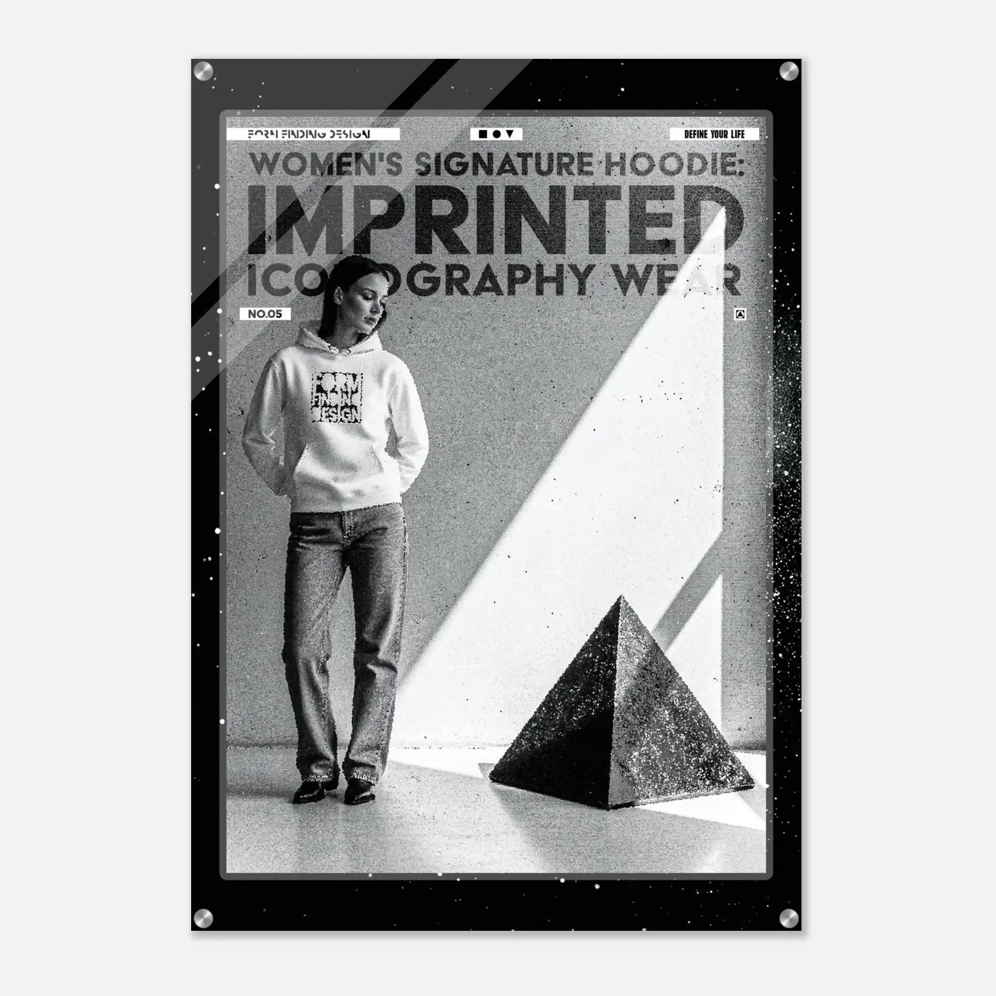 A black and white fashion poster print featuring a model wearing a hoodie and jeans, with bold text reading 'WOMEN'S SIGNATURE HOODIE: IMPRINTED ICONOGRAPHY WEAR' and a black geometric pyramid in the foreground.