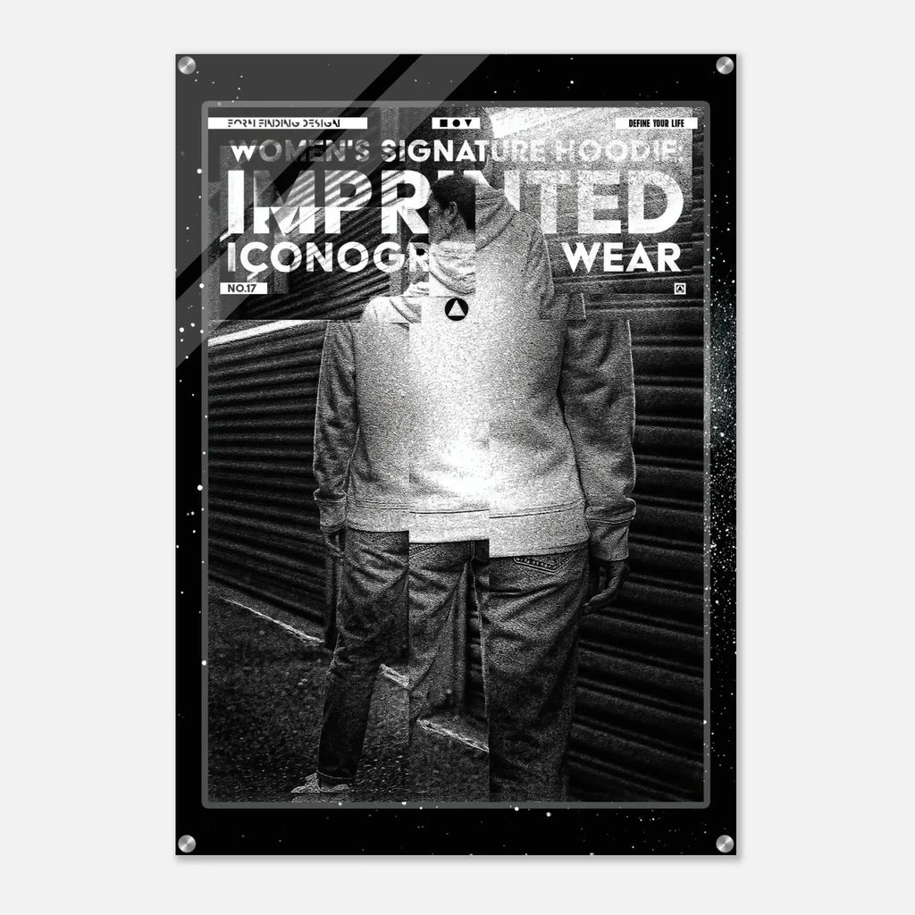 A black and white fashion poster print featuring a stylized figure in front of a corrugated metal wall, with bold text reading 'WOMEN'S SIGNATURE HOODIE' and 'IMPRINTED ICONOGRAPHY WEAR'. The poster is shown hanging against a light gray wall.