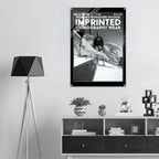 A black and white poster print hanging on a light gray wall above a white and dark wood console shelf, styled in a modern minimalist room with a tripod floor lamp.