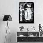 A black and white poster featuring a hooded figure with the text 'WOMEN'S SIGNATURE HOODIE IMPRINTED ICONOGRAPHY WEAR' displayed on a light gray wall above a shelf in a modern room setting.