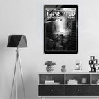 A black and white poster with the text 'WORKER'S SIGNATURE HOODIE: IMPRINTED ICONOGRAPHY WEAR' hangs on a light gray wall above a dark wood shelf in a modern room setting.