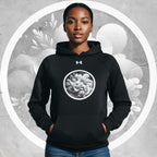 Lifestyle front shot of model in the black Form Finding Design Under Armour® x Ring Stamp Hoodie (No.09), hands in kangaroo pocket, circular monochrome wave ring emblem centred, grey textured background with a bold white halo ring.