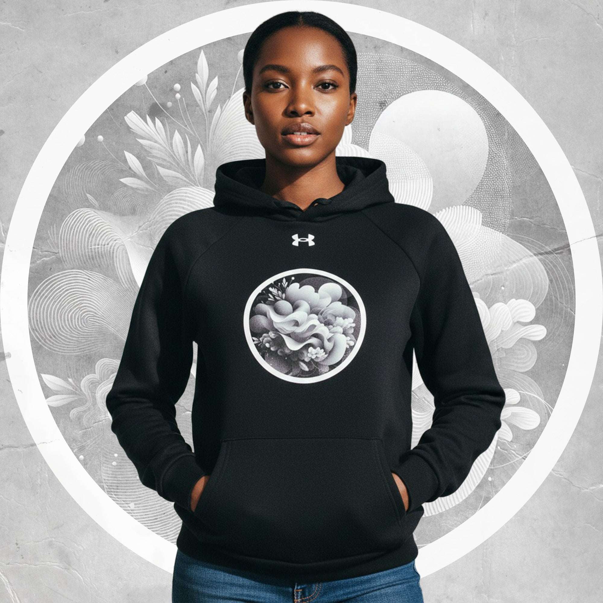 Lifestyle front shot of model in the black Form Finding Design Under Armour® x Ring Stamp Hoodie (No.09), hands in kangaroo pocket, circular monochrome wave ring emblem centred, grey textured background with a bold white halo ring.