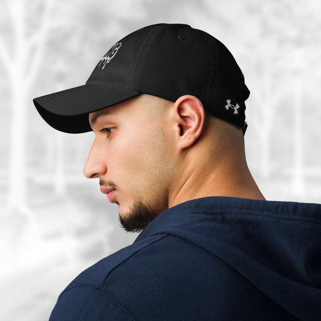 Profile view of a man in the Under Armour x Title-3 Finding Logo Cap showing the curved brim and hint of the white “Finding” embroidery on the front; an Under Armour logo tag sits on the fabric strap, with tonal eyelets above his ear.