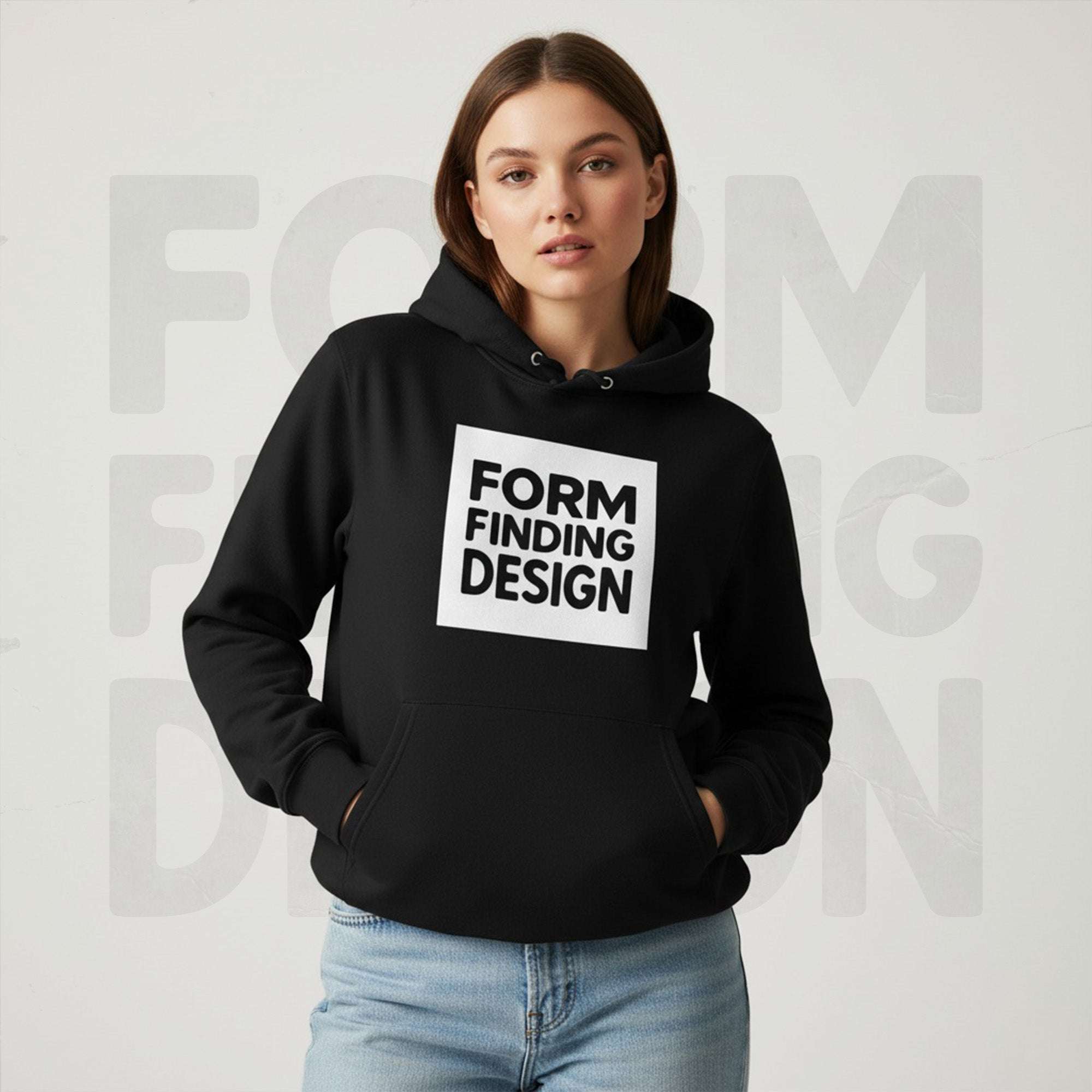 Lifestyle front portrait: model in black Form Finding Design Women’s Signature Hoodie (FFD-20)—white square logo print, kangaroo pocket, casual fit with light denim.