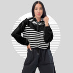 Front pose of model in FormFD Women’s ICN Cropped Windbreaker—half-zip hooded cropped windbreaker with high-contrast black stripe motif across chest and sleeves.