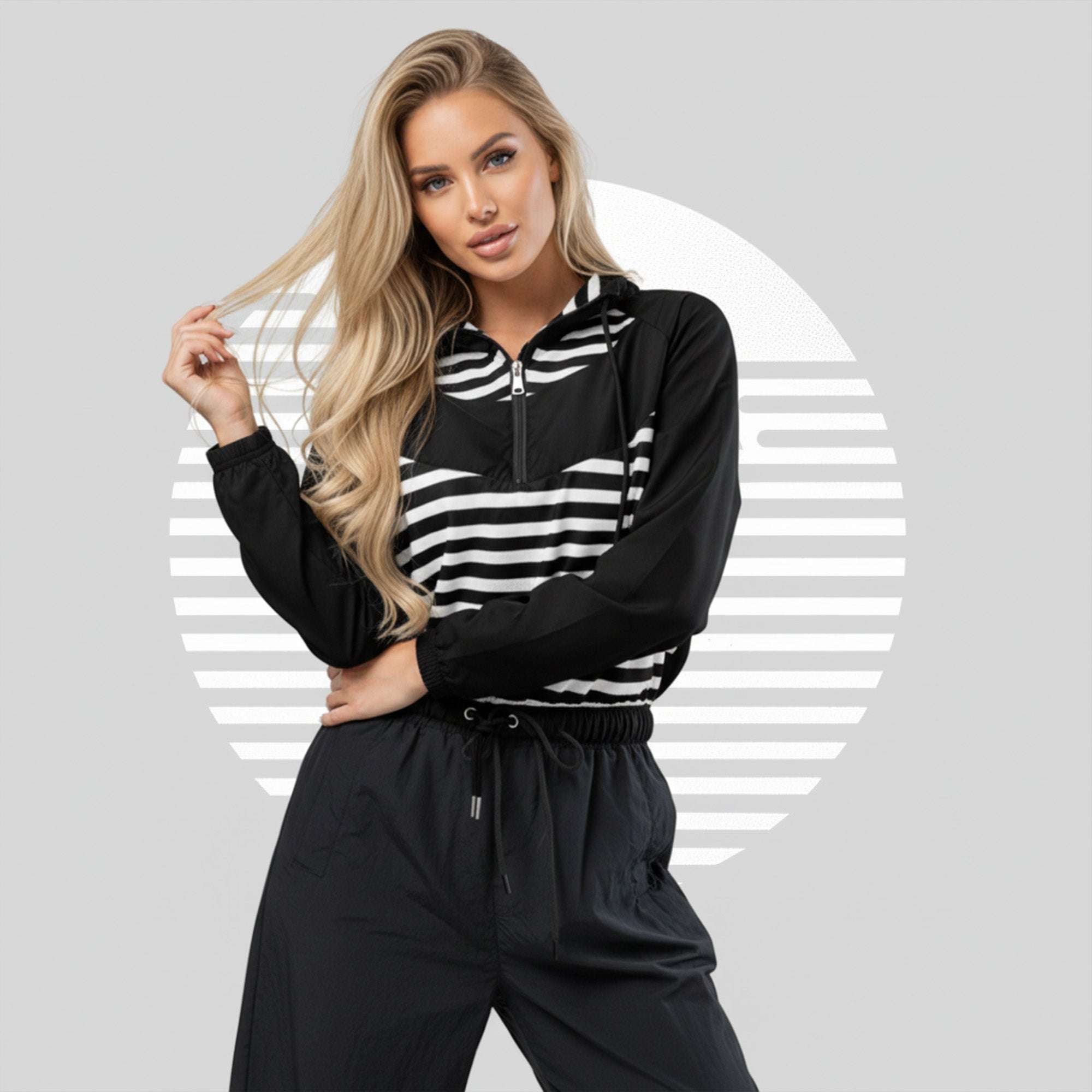 Lifestyle portrait of Form Finding Design Women’s ICN Cropped Windbreaker—cropped half-zip windbreaker with monochrome stripe band and geometric panels, minimalist graphic backdrop.