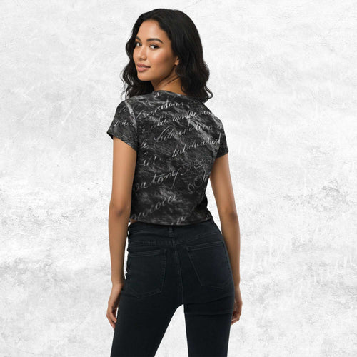 Three-quarter side/back view of model in Form Finding Design Women’s Era Print (No.11) crop tee — distressed monochrome newsprint collage print, cropped hem, fitted sleeves, paired with black jeans.