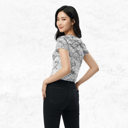 Three-quarter side/back view of model in Form Finding Design Women’s Era Print (No.12) crop tee — distressed monochrome newsprint collage print, cropped hem, fitted sleeves, paired with black jeans.
