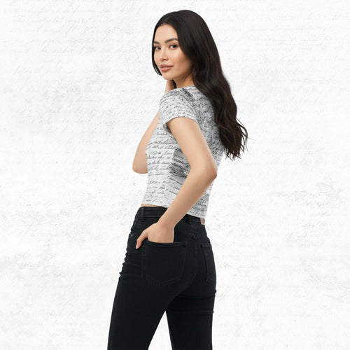 Three-quarter side/back view of model in Form Finding Design Women’s Era Print (No.20) crop tee — distressed monochrome newsprint collage print, cropped hem, fitted sleeves, paired with black jeans.