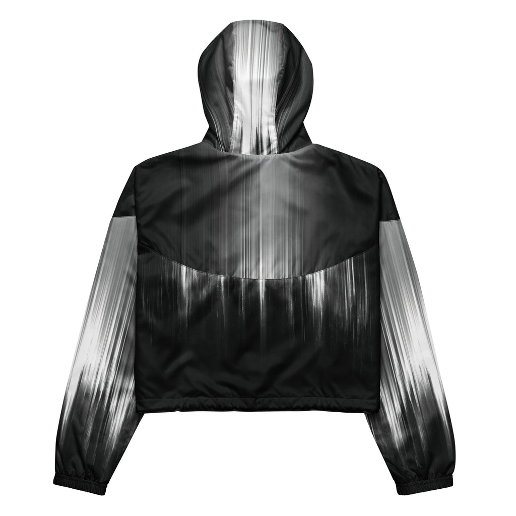 Back studio view of the HER Cropped Dither Distortion Windbreaker (No.02), showing the hood and cropped silhouette. The digital distortion print runs from light grey at the upper back to deep charcoal at the hem; the hood’s outer panels are colour‑blocked in black and white, and the elasticated hem is cinched with a drawcord, all set against a clean white backdrop