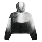 Back studio view of the HER Cropped Dither Distortion Windbreaker (No.08), showing the hood and cropped silhouette. The digital distortion print runs from light grey at the upper back to deep charcoal at the hem; the hood’s outer panels are colour‑blocked in black and white, and the elasticated hem is cinched with a drawcord, all set against a clean white backdrop